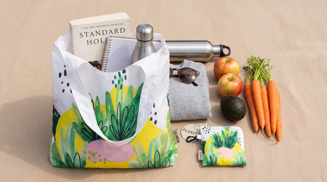 PLURiTy roll-up reusable tote shown with everyday items to demonstrate practical carrying capacity.